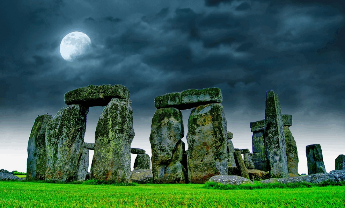 Stonehenge at night under a bright moon and dark clouds